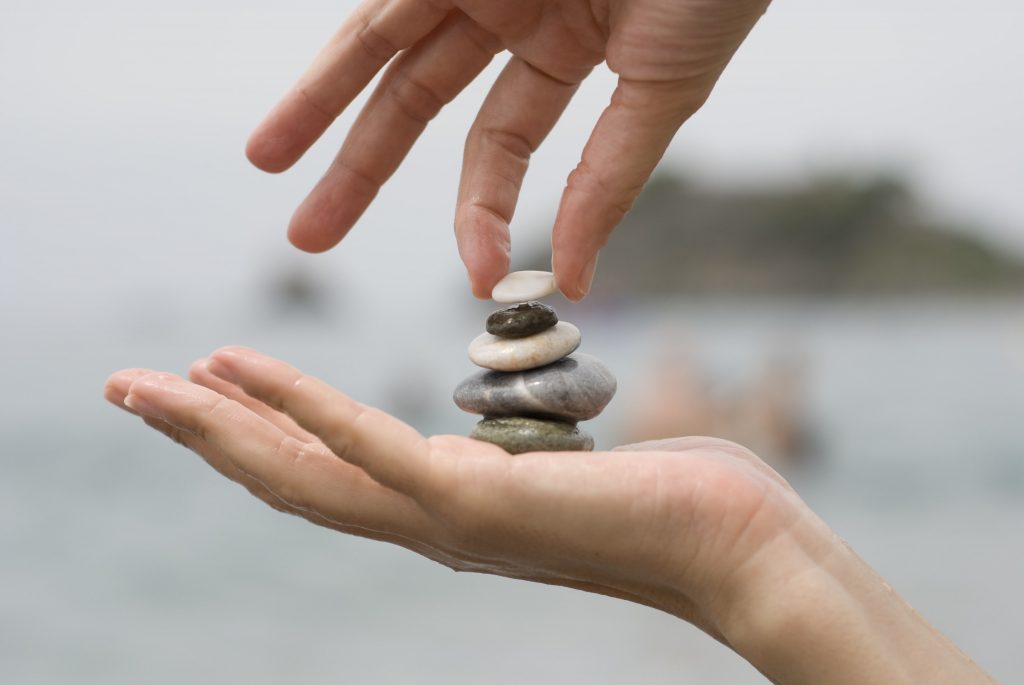 putting last pebble pile stones 1024x685 - Wellness como complemento al Pilates